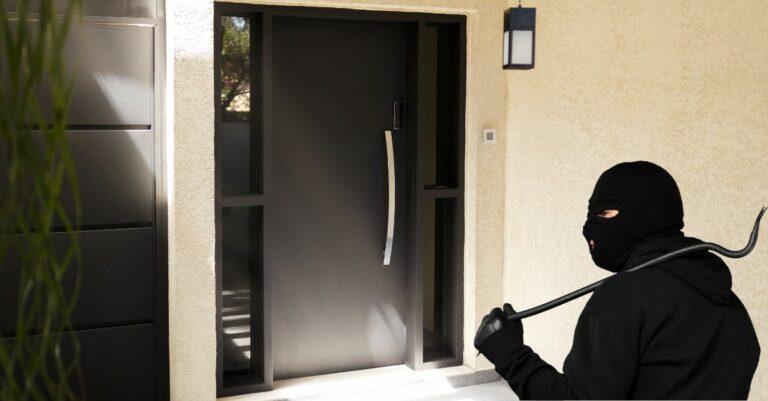 Un cambrioleur devant une porte de maison